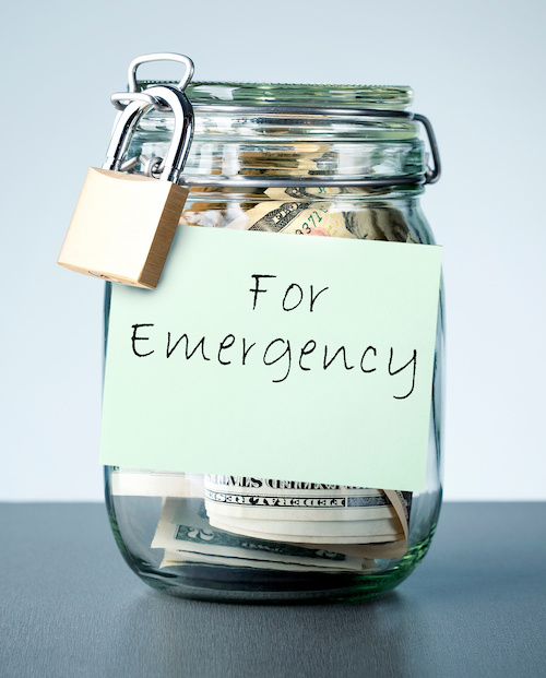 glass jar with crumpled dollar bills inside, with padlock and handwritten sign that says "For Emergencies"